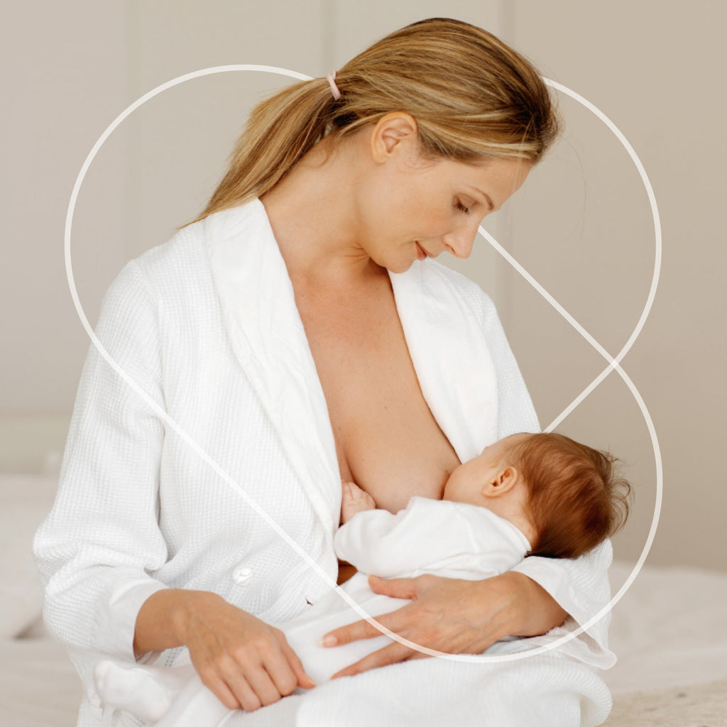 mom breastfeeding baby while wearing white robe